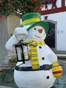 Deko-Schneemann beleuchtet mit Laterne als Weihnachtsdeko draussen