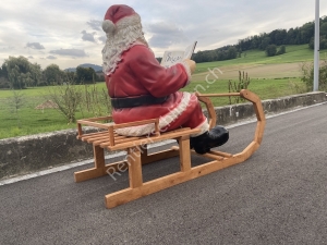 Grosser Weihnachtsmann auf Schlitten liest im Buch